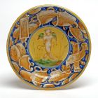 Ornamental plate - Amor playing with trophies and a ribbon